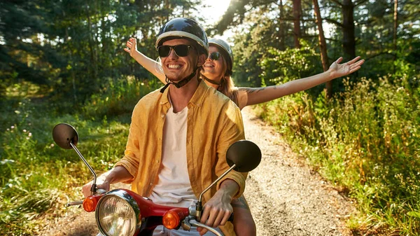 Happy young caucasian couple driving scooter — Stock Photo, Image