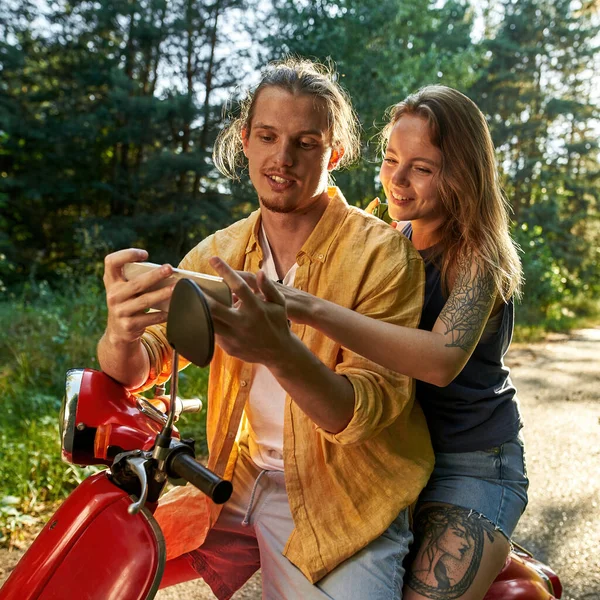 Χαμογελώντας νεαρό καυκάσιο ζευγάρι ψάχνει σε smartphone — Φωτογραφία Αρχείου