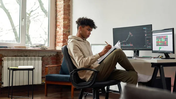 Millennial biracial hombre comercio estudio en línea con el libro y el comercio en el mercado de valores y cripto — Foto de Stock