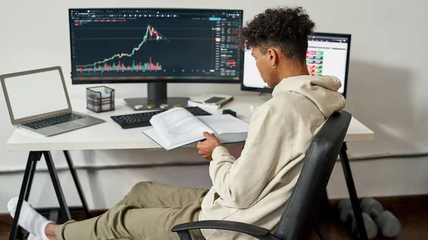 Etnische mannelijke handelaar lees boek werk online — Stockfoto