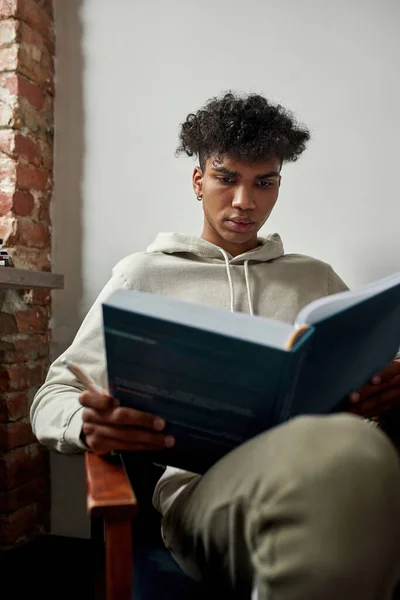 Millennial ragazzo afroamericano letto libro in sedia — Foto Stock