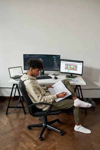 Milenial comerciante masculino trabaja en el mercado de valores en PC mientras estudia — Foto de Stock