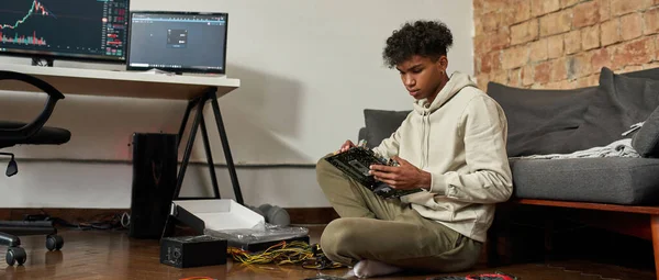 Hombre afroamericano reparar el hardware de la computadora en casa. Equipos de minería — Foto de Stock