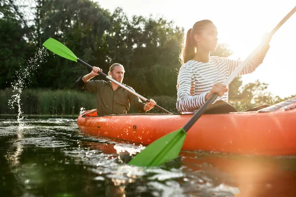 年轻的高加索夫妇在休闲活动中玩乐，在独木舟河里划船 — 图库照片