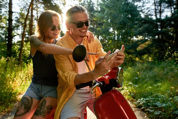 Feliz joven caucásico hombre y mujer en scooter — Foto de Stock