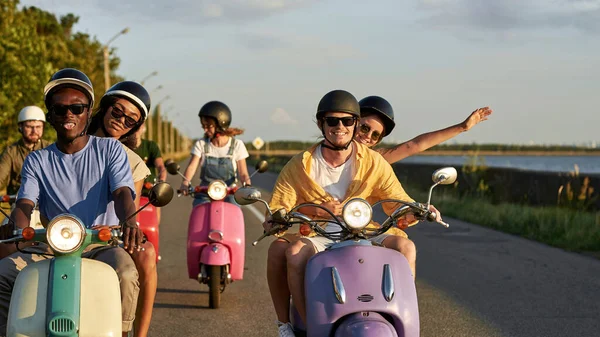 Jovens amigos alegres andando de moto scooters no fim de semana fora da cidade — Fotografia de Stock