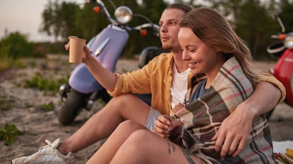 Retrato de pareja relajada conversando, disfrutando de la vista, viendo atardecer en la playa fuera de la ciudad — Foto de Stock