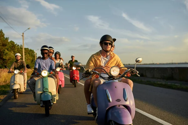 朋友们在路上一起骑摩托车时戴着头盔，周末在城外度过 — 图库照片