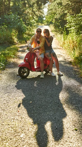 Niedliche junge kaukasische Paar Roller fahren in Holz — Stockfoto