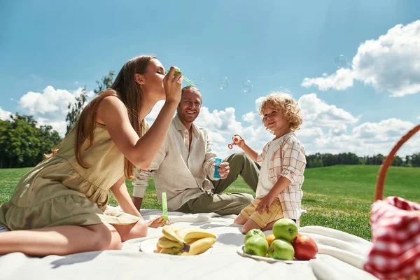 Gelukkig klein kind hebben plezier terwijl het doorbrengen van tijd met zijn ouders, familie picknick in de natuur op een zomerdag — Stockfoto