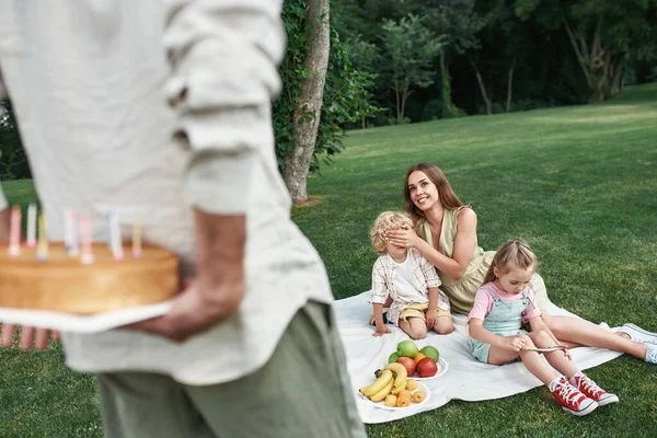 Far förberedde en överraskning åt sin son. Familjen kopplar av, har picknick i parken, firar barnens födelsedag tillsammans utomhus en sommardag — Stockfoto