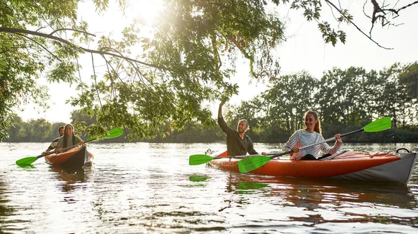 Persone felici attive che si divertono insieme mentre fanno kayak sul fiume in una giornata di sole durante le vacanze estive — Foto Stock