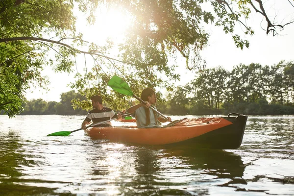 Samen varen in de rivier, omringd door bomen in de lente of de zomer, samen buiten. — Stockfoto