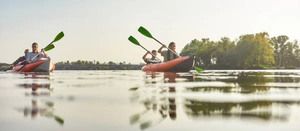 Actieve vrienden die het weekend samen doorbrengen kajakken in een boot op een rivier op een zomerdag — Stockfoto