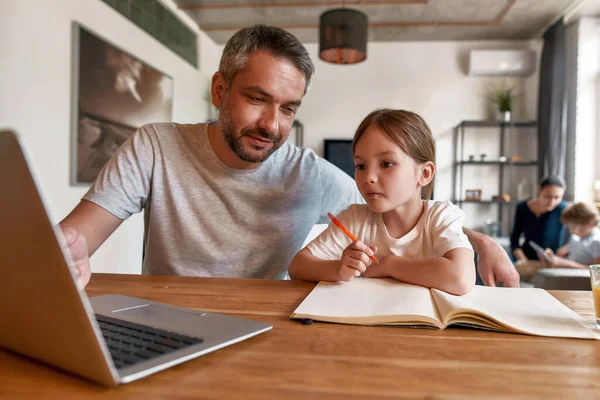 Menina pequena criança fazer lição de casa on-line com o pai em casa — Fotografia de Stock