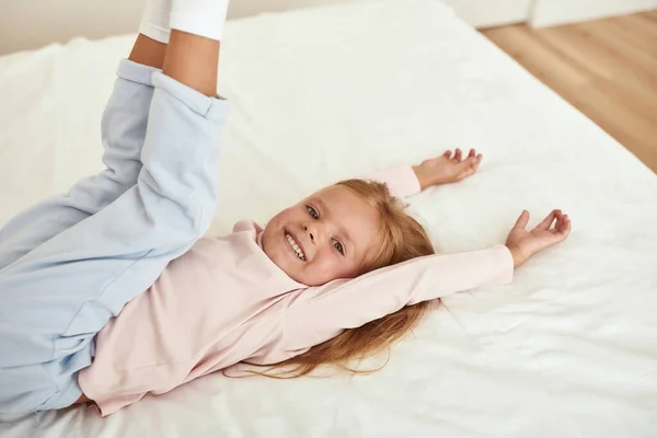 Портрет счастливой девочки, играющей в спальне — стоковое фото