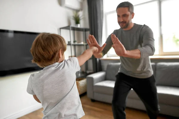 Sportif genç çocuk babasıyla evde antrenman yapıyor. — Stok fotoğraf