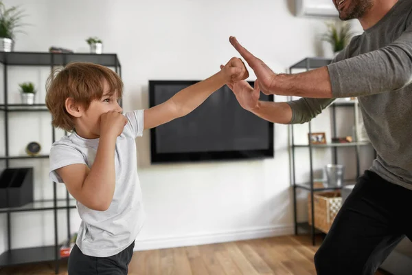 Sportig tonåring pojke motion med pappa hemma — Stockfoto