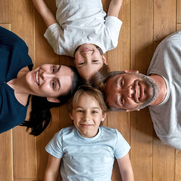 Portret van lachende ouders met kleine kinderen ontspannen — Stockfoto