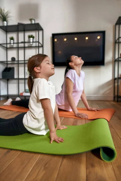 Vertikalt skott av sportig mamma och dotter gör yoga — Stockfoto