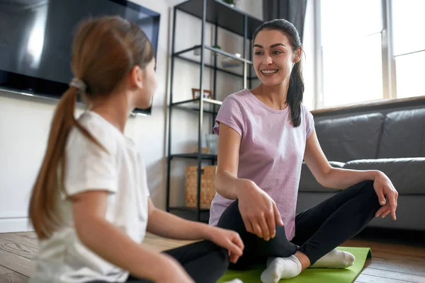 Leende sportig mor och liten dotter tåg — Stockfoto