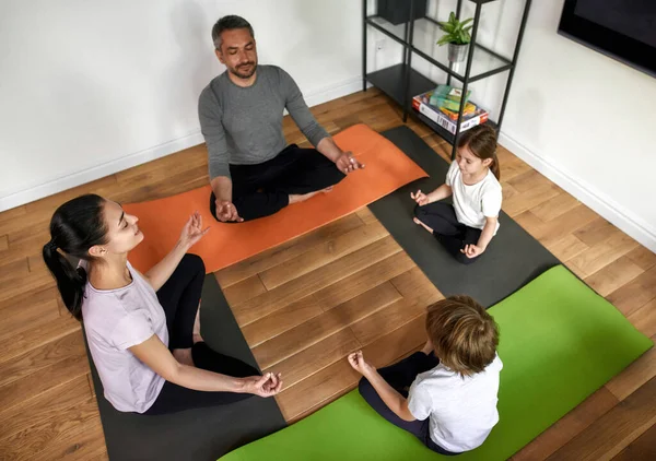 Upp och ner av föräldrar med små barn meditera tillsammans — Stockfoto