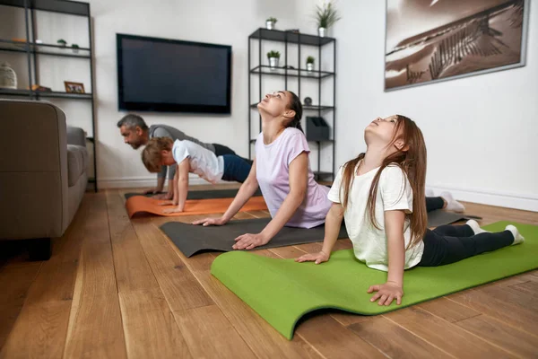 Sportig familj med barn tränar tillsammans hemma — Stockfoto