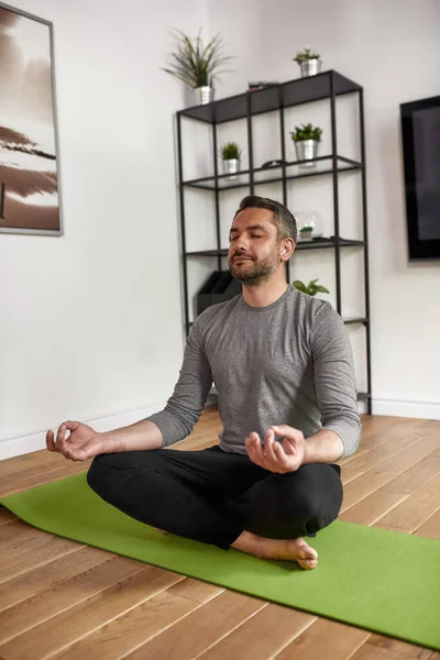 Lugn ung man meditera utöva yoga hemma — Stockfoto