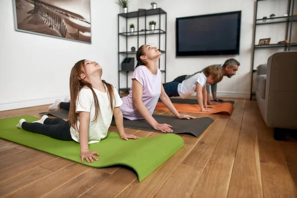 Aktiv familj med barn gör morgongymnastik hemma — Stockfoto