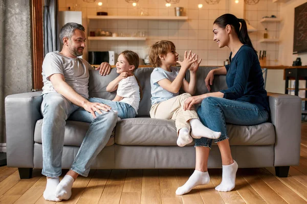 Glada barn pratar med unga vita föräldrar — Stockfoto