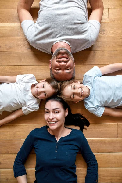 Verticaal portret van gelukkige ouders met kinderen ontspannen samen — Stockfoto