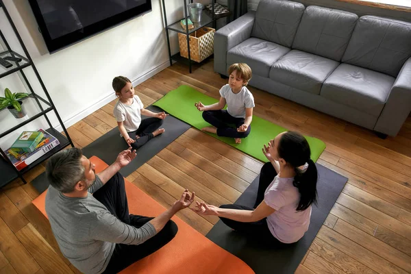 Upp och ner familj med barn meditera hemma — Stockfoto