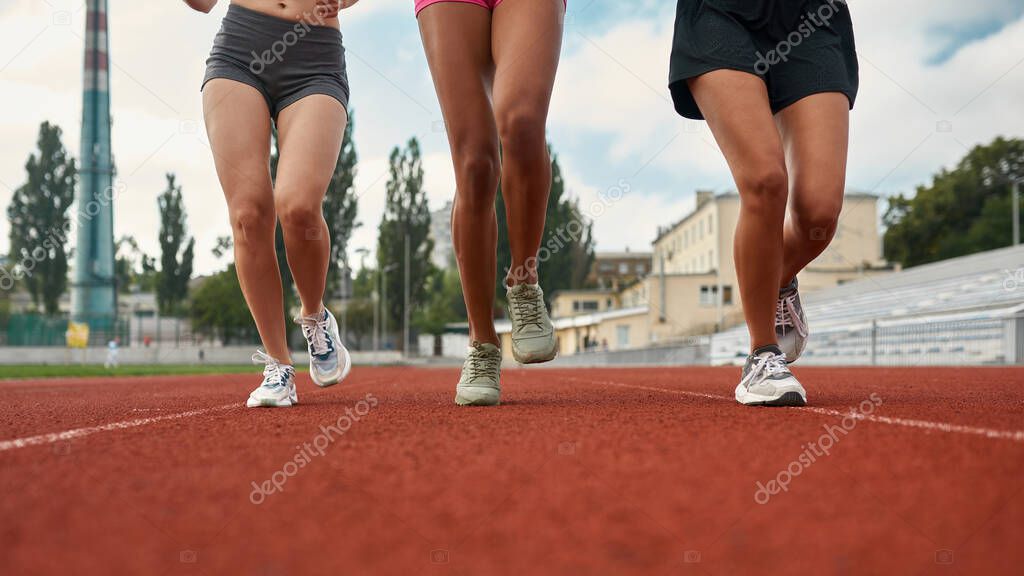 Colpo ritagliato di gambe di tre corridori professionisti femminili in  abbigliamento sportivo che corrono insieme sul campo di atletica allo  stadio - Foto Stock: Foto, Immagini © LanaStock 508399266 | Depositphotos