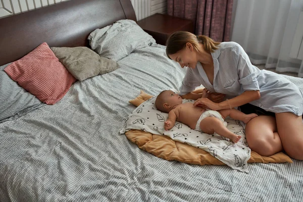 Kasih sayang ibu melihat bayi tergeletak di dekatnya — Stok Foto