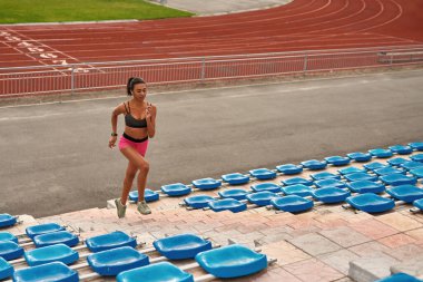 Profesyonel genç bayan bir yaz günü stadyumda antrenman yapıyor.