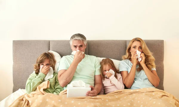 Ritratto di famiglia malata con bambini malati a letto — Foto Stock