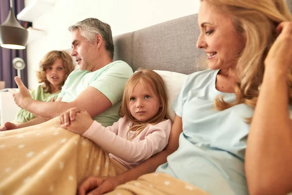 Lycklig familj med barn koppla av i sängen på lockdown — Stockfoto