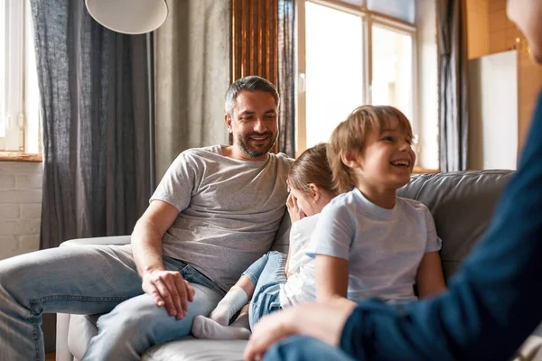 Lachende kleine kinderen ontspannen thuis pratend met ouders — Stockfoto