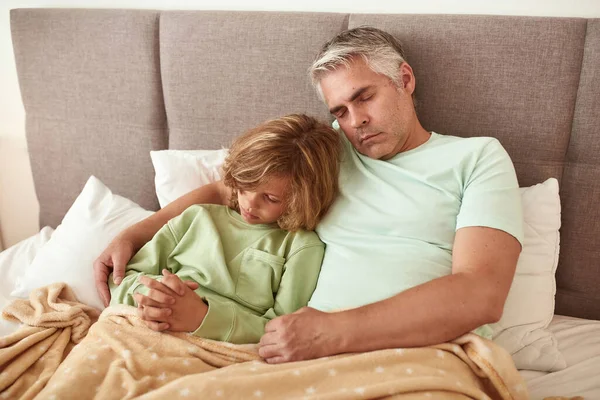 Sağlıksız baba ve oğul yatakta dinleniyor.