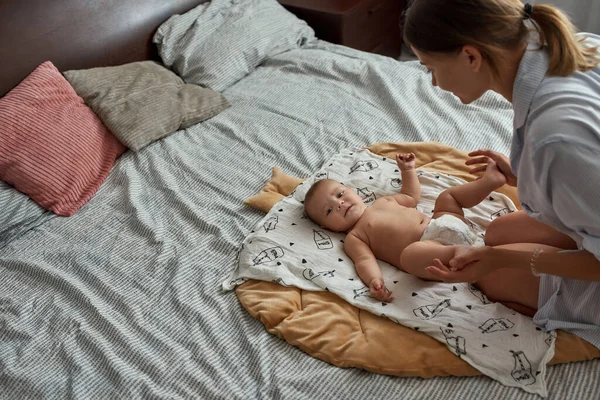 Mom providing morning routine, warming up her infant baby — Stock Photo, Image