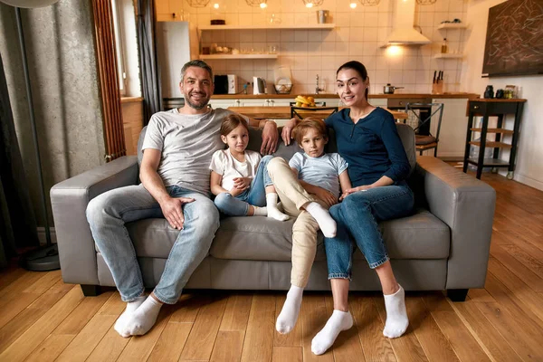 Porträtt av lycklig familj med barn koppla av på soffan — Stockfoto