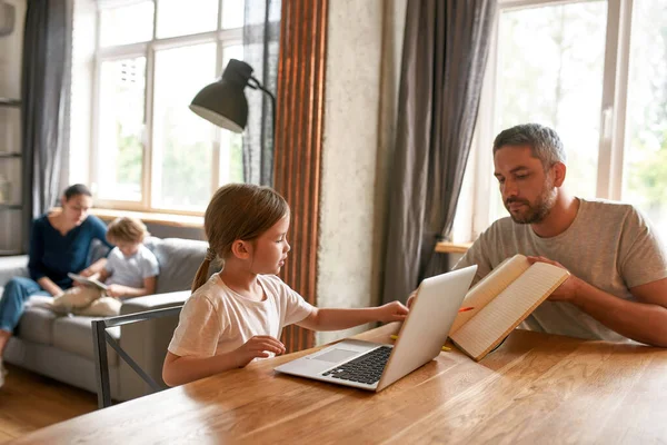 Pai carinhoso fazer lição de casa on-line com a filha pequena em casa — Fotografia de Stock