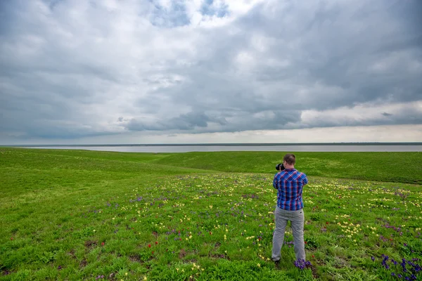 Outdoor photographer in spring meadow — Stock Photo, Image