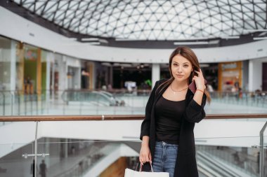 Alışveriş merkezinde güzel, siyah saçlı bir kız.