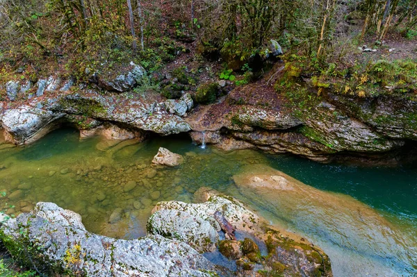 Paysage d'automne avec ruisseau de montagne coulant entre des pierres moussues — Photo
