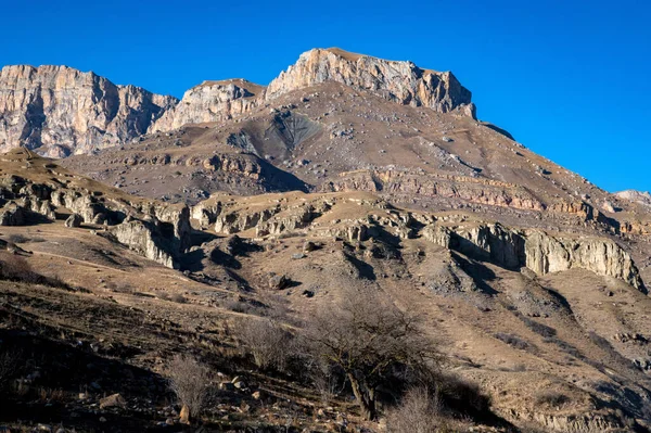 Rocas y hierba seca en las montañas del Cáucaso Norte en otoño en un día soleado — Foto de Stock