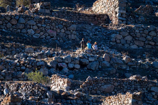 Toeristen in oude stenen in verlaten Balkar dorp in Noord-Kaukasus — Stockfoto
