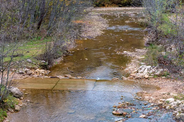 Осенний пейзаж с горным сухим ручьем с порогами и лесом — стоковое фото