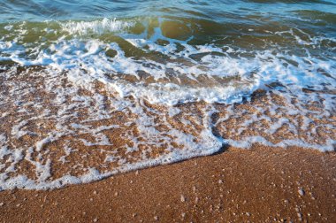 Deniz suyunun kapağı kumlu sahile akıyor..