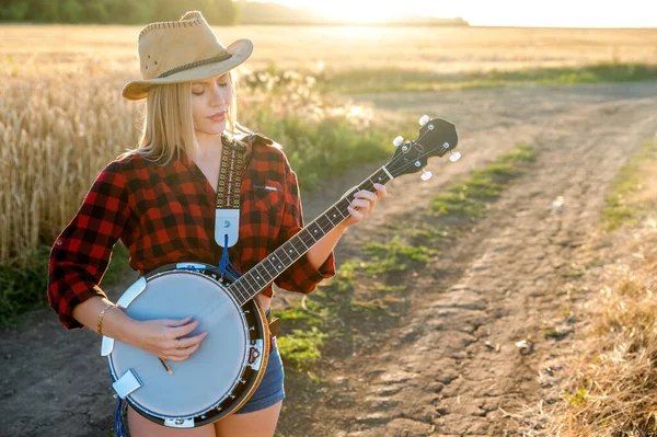 Una campesina con un banjo se queda en un campo —  Fotos de Stock